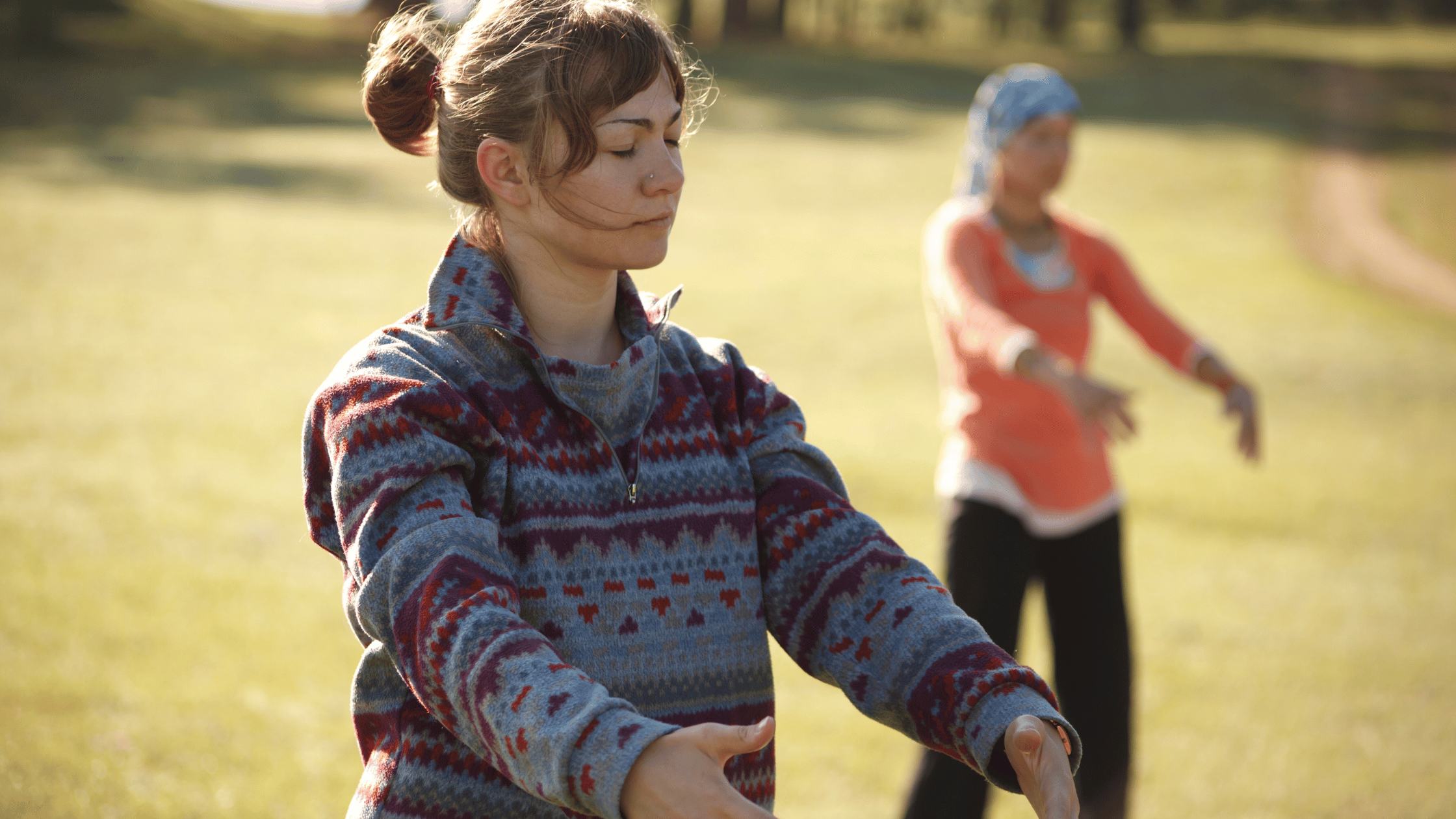 two women practicing qi gong outside