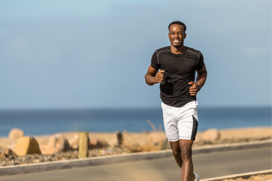 Man in black shirt and white shorts, running.