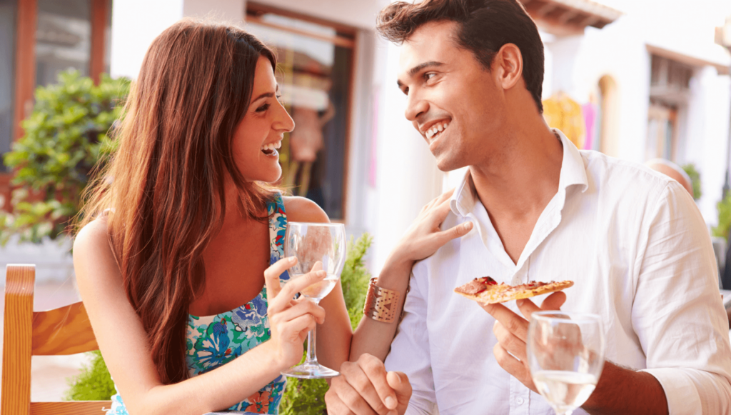 Two people eating pizza and drinking water.