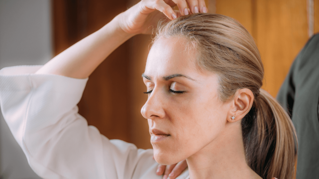 a woman activating governing vessel by tapping the top of her head