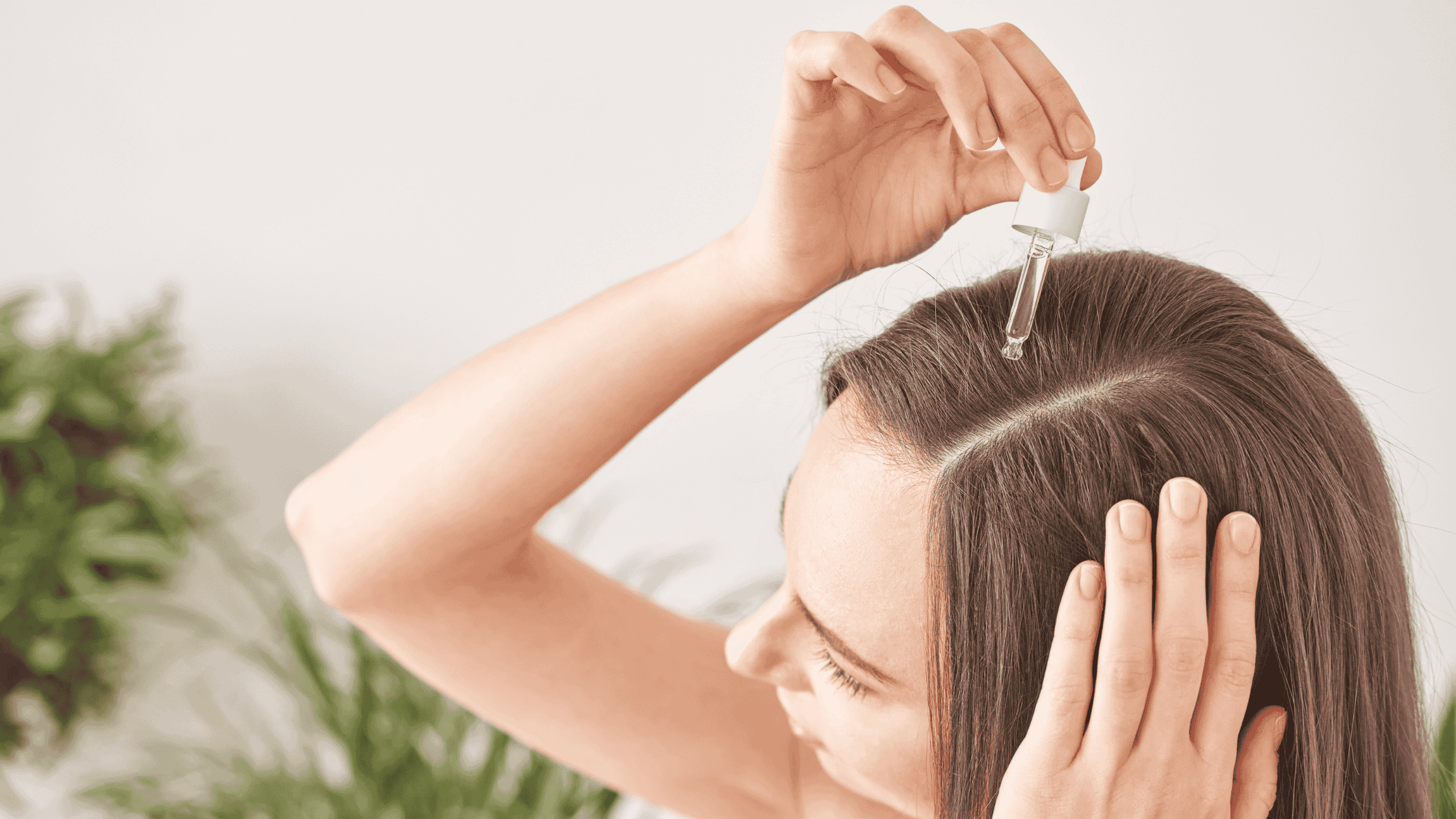 A woman putting castor oil in her scalp.