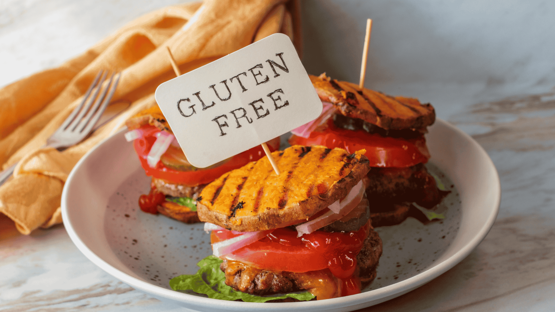 A plate of gluten-free food, with a sweet potato burger and a sign that says gluten-free.