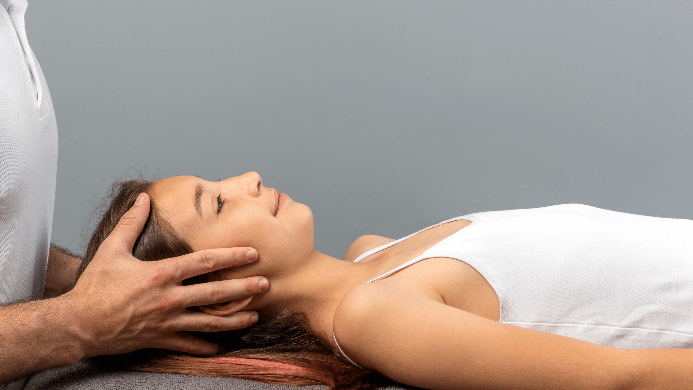 woman lying on massage table and having treatment on her head and neck