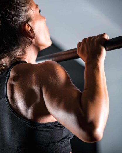 athletic woman doing pull ups and working on athletic performance